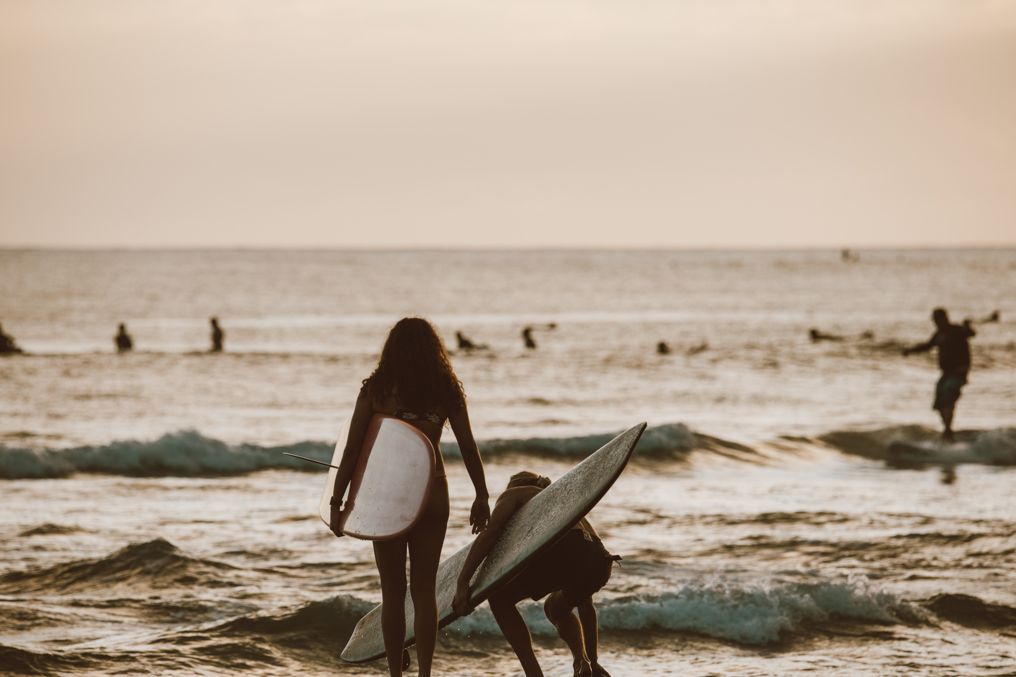 Woman in White Tank Top Holding White Surfboard on Beach
